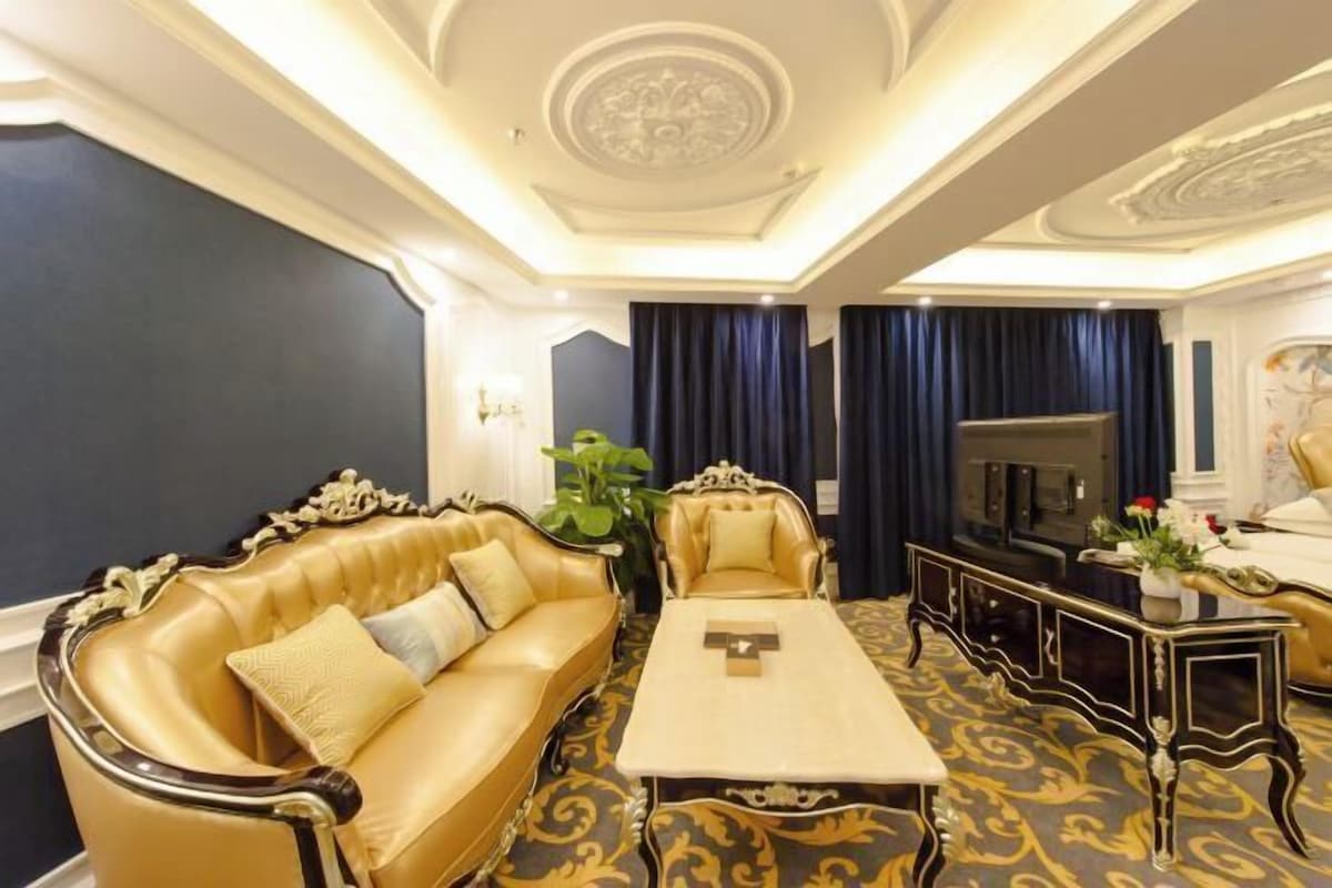 A room with a sofa, a coffee table, a TV, and a decorative plant.