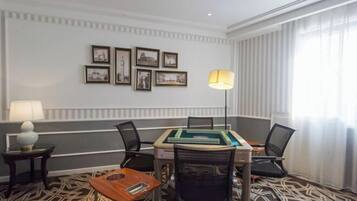 A conference room with a table, chairs, framed pictures on the wall, and a lamp.