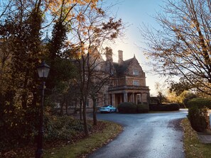 A historic building with a stone facade, a driveway, and a car parked in front. - Capella Cottage, 2 Bedroom, Sleeps 4 (Lincoln)