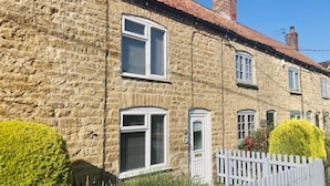 A stone building with multiple windows, a white picket fence, and well-maintained hedges. - Capella Cottage, 2 Bedroom, Sleeps 4 (Lincoln)