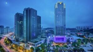 A high-rise building with a prominent entrance and a lit-up facade at dusk. - Empark Grand Hotel (Guiyang)