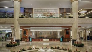 A spacious lobby with a reception desk, large columns, and a glass railing overlooking the lower level. - Empark Grand Hotel (Guiyang)