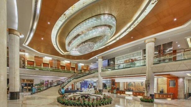 A spacious lobby with a grand chandelier, multiple levels, and a central staircase. - Empark Grand Hotel (Guiyang)
