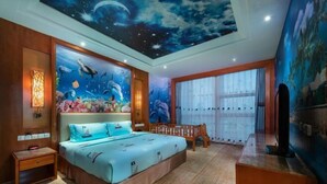 A bedroom with a large bed, a nightstand, a desk, and a mural of an underwater scene on the ceiling. - Empark Grand Hotel (Guiyang)