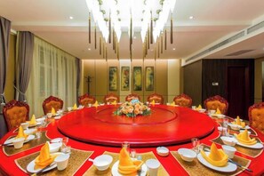 A conference room with a round table, chairs, and a chandelier.