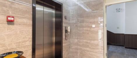 Ein Hotelaufzug mit einem Schild, das die Etage 1F anzeigt.