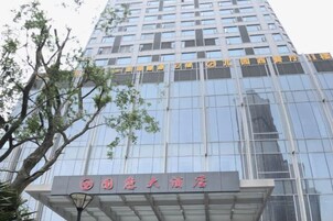 Un edificio moderno con fachada de vidrio y un cartel que indica que es un hotel.