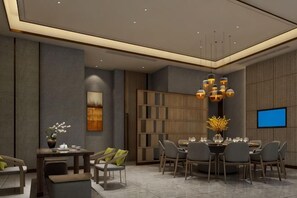 A modern dining area with a round table, chairs, and a television screen. - Guohui Hotel (Minhou Ganzhe) (Minhou)