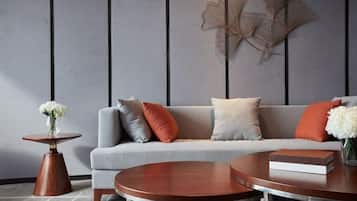 A modern living room with a grey sofa, round coffee table, and decorative wall art.