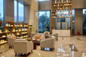 A spacious lobby with seating areas and a large bookshelf. - Guohui Hotel (Minhou Ganzhe) (Minhou)