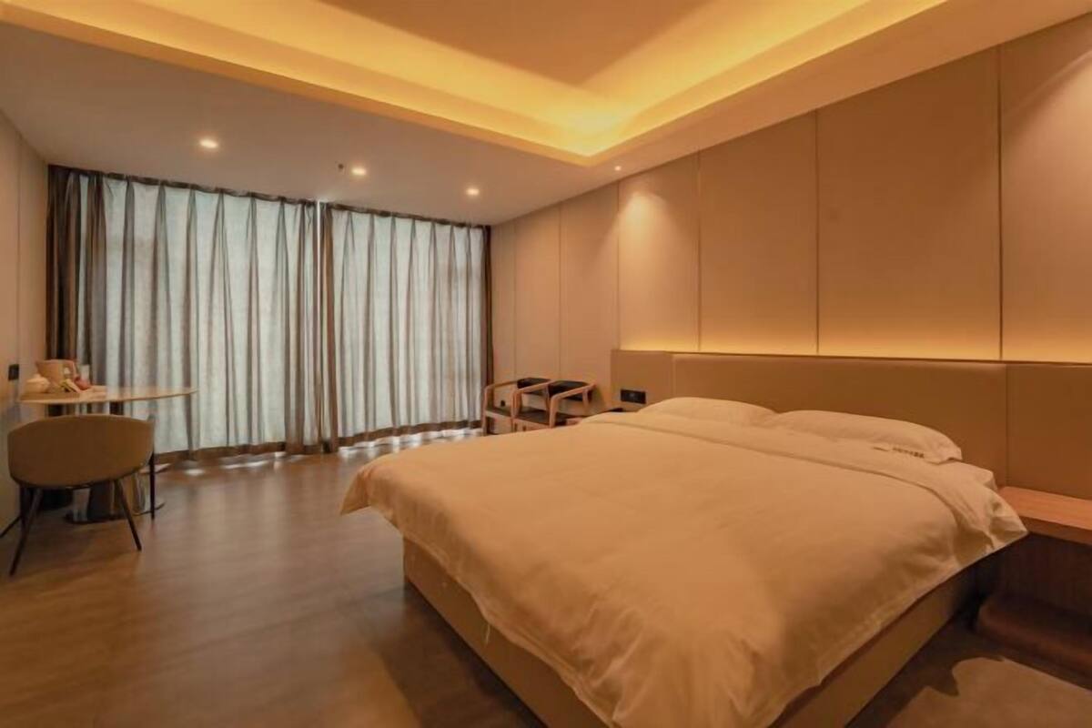 Une chambre d’hôtel moderne, dotée d’un grand lit, d’un bureau et d’une chaise.