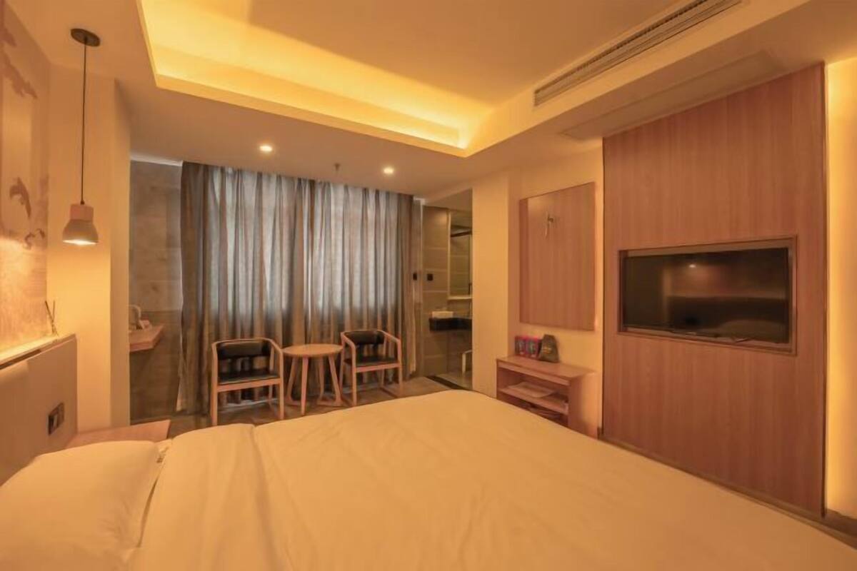 Une chambre d’hôtel avec un lit, une télévision, un bureau et une chaise.