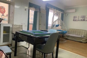 Una habitación con una mesa de comedor, una silla, un sofá y una sillona colgante.
