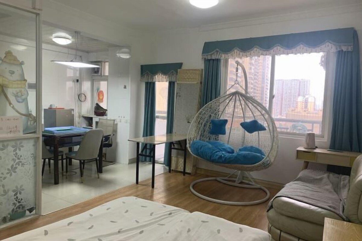 A room with a hanging chair, a dining area, and a view of the city.