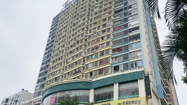 A multi-story building with a curved facade, featuring balconies on each floor.