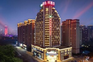 A multi-story hotel building with illuminated signage and a well-lit entrance.
