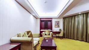 A hotel room with a sofa, armchairs, a coffee table, a desk, and a curtain. - Vienna Hotel (Zaozhuang Xuecheng Distrct High-speed Railway Station) (Zaozhuang)
