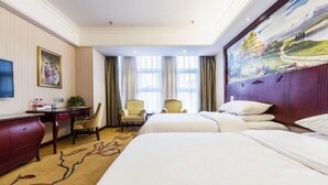 A hotel room with two beds, a desk, a chair, and a painting on the wall. - Vienna Hotel (Zaozhuang Xuecheng Distrct High-speed Railway Station) (Zaozhuang)