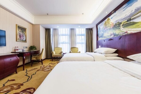 A hotel room with two beds, a desk, a chair, and a painting on the wall. - Vienna Hotel (Zaozhuang Xuecheng Distrct High-speed Railway Station) (Zaozhuang)