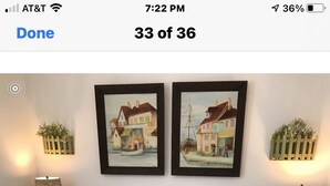 A bedroom with a bed, two nightstands, two lamps, and two framed pictures on the wall. - Bam!!! August Special rate 79 guests love this little paradise!  Private pool! (Gulf Breeze)