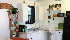 A compact living space with a red sofa, a kitchenette with white cabinets, and a small dining area. - Bam!!! August Special rate 79 guests love this little paradise!  Private pool! (Gulf Breeze)