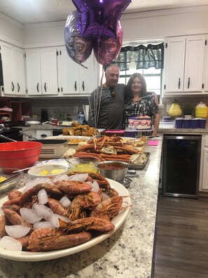 A kitchen with white cabinets, a countertop with food items, and balloons. - Bam!!! August Special rate 79 guests love this little paradise!  Private pool! (Gulf Breeze)