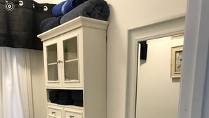 A bathroom with a toilet, a sink, a cabinet with towels, and a mirror. - Bam!!! August Special rate 79 guests love this little paradise!  Private pool! (Gulf Breeze)