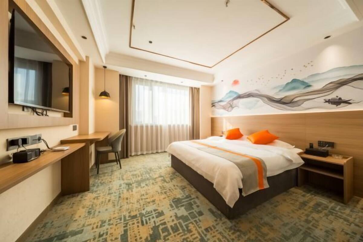 Una habitación de hotel con cama, escritorio y televisión.