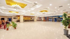 A spacious lobby with chandeliers, potted plants, and a reception desk. - Mingzhao Hot Spring International Hotel (Wuyi)