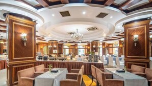 A restaurant with round tables and booths, wooden paneling, and chandeliers. - Mingzhao Hot Spring International Hotel (Wuyi)