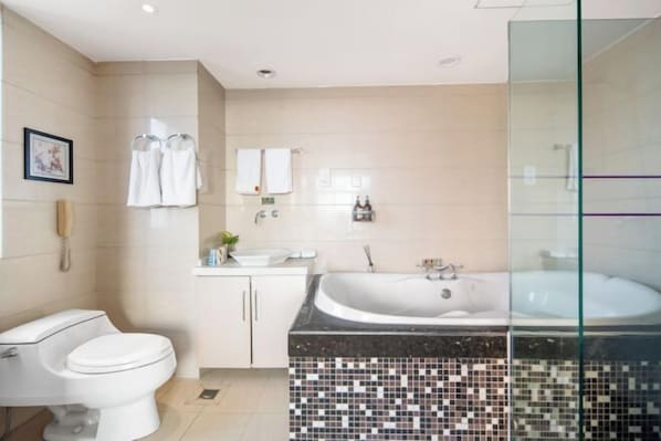 A modern bathroom with a toilet, sink, and bathtub. - Mingzhao Hot Spring International Hotel (Wuyi)