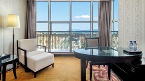 A hotel room with a balcony, a round glass table, a sofa, and a lamp. - Mingzhao Hot Spring International Hotel (Wuyi)
