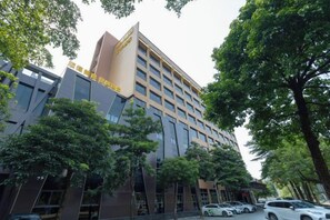 A multi-story hotel with a modern architectural design, featuring a prominent entrance and a series of windows on the facade. - Xiya Hotel (Foshan)
