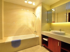Een moderne badkamer met een bad, een wastafel en een spiegel.