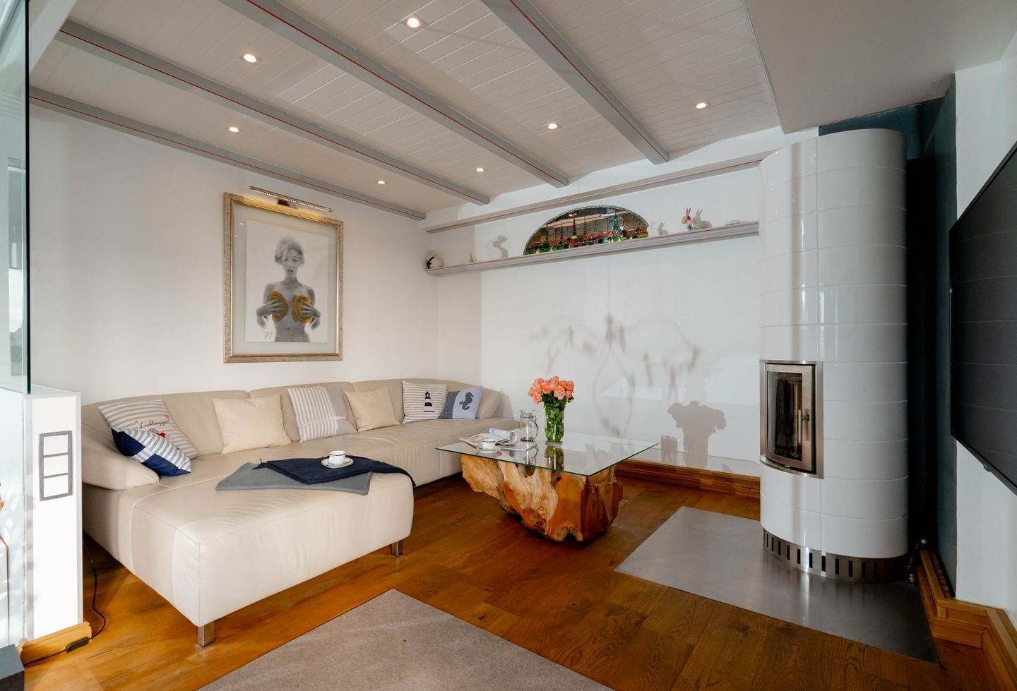 Una sala de estar moderna con un sofá color beige, una mesa de centro de vidrio y una chimenea.