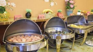 A buffet setup with multiple food stations, including a station with eggs and another with what appears to be a variety of meats.