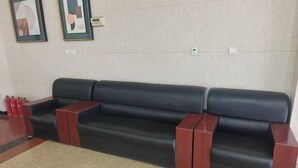 A black leather sofa with wooden armrests in a lobby area. - Sunshine Hotel (Yuncheng Wanda Plaza Central Hospital) (Yuncheng)