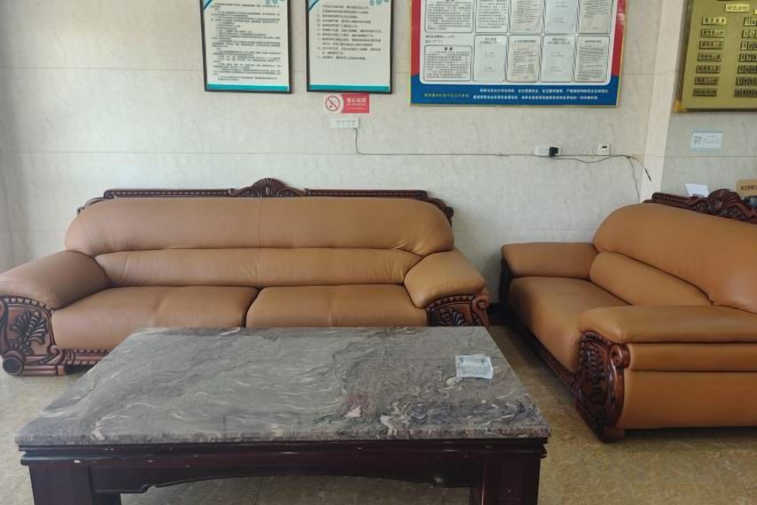 A room with two brown leather sofas and a wooden coffee table.