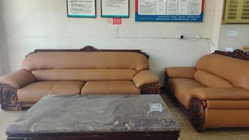 A room with two brown leather sofas and a wooden coffee table.