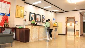 A reception area with a counter, chairs, and a wall with framed pictures.