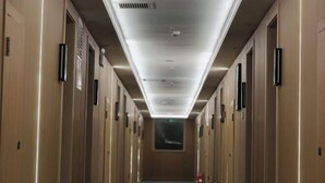 A long, narrow hotel corridor with doors on both sides, a central walkway, and a ceiling with recessed lighting. - Sunshine Hotel (Yuncheng Wanda Plaza Central Hospital) (Yuncheng)