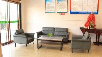 A reception area with a sofa, two armchairs, a coffee table, and a statue.