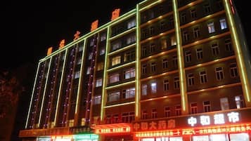 A multi-story hotel with illuminated signage and multiple floors.