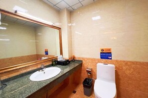 A bathroom with a sink, mirror, and toilet. - Baima Hotel (Damxung)