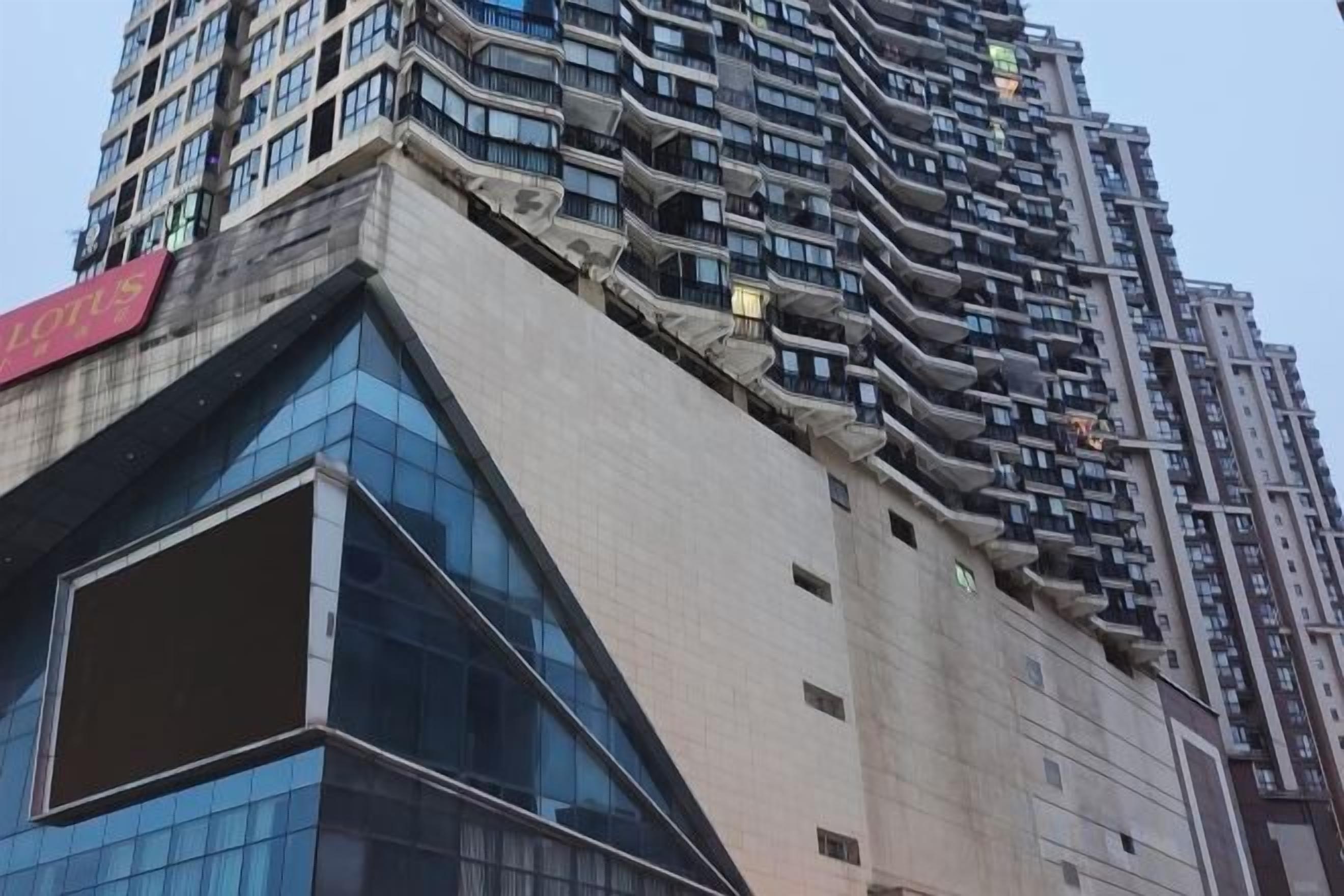 A high-rise building with a unique architectural design, featuring a series of balconies and a prominent glass facade.