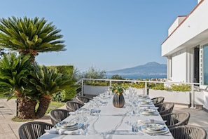 Mesa lista para comer con vistas al mar y a las montañas.