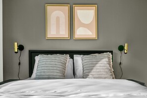 A bed with white bedding, two pillows, and two wall-mounted light fixtures. - Roomy Landstraße 1BR w/ Elevator, near Metro U3, by Blueground (Vienna)
