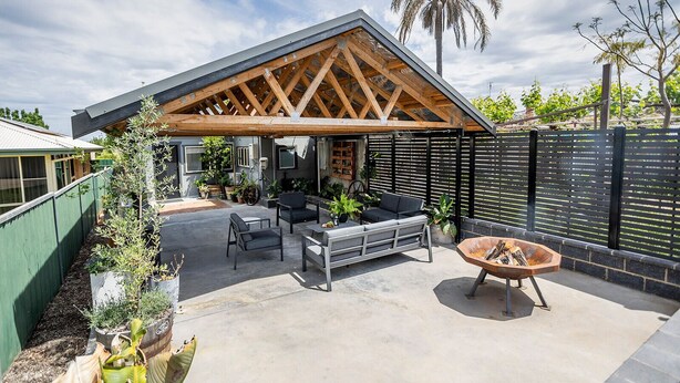 A covered outdoor patio with seating and a fire pit. - Cabos On Currajong! (Parkes)