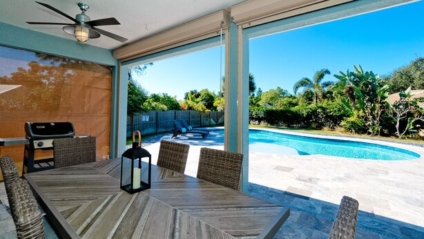 Zona de piscina con mesa, sillas, parrilla y una linterna.
