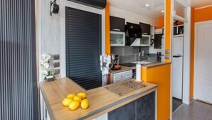 Una cocina moderna con encimera de madera, horno empotrado y campana extractora negra.